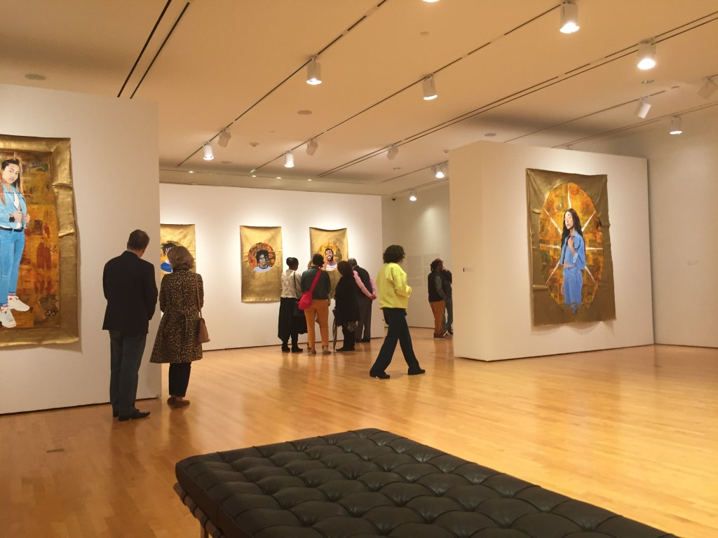 A group of viewers looking at Shell's artwork at the gallery.
